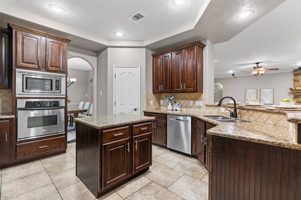 Kitchen has an island, stainless steel appliances, gas range.