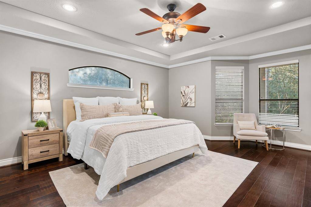Spacious primary suite with wood flooring.