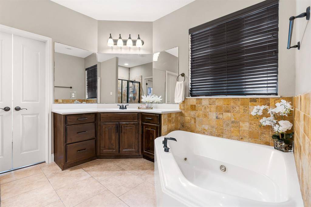 Primary bath with dual vanities, jetted tub for relaxing.