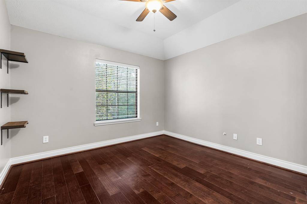 Spacious secondary bedroom with shelving. Take note of the wooden flooring throughout the upstairs.
