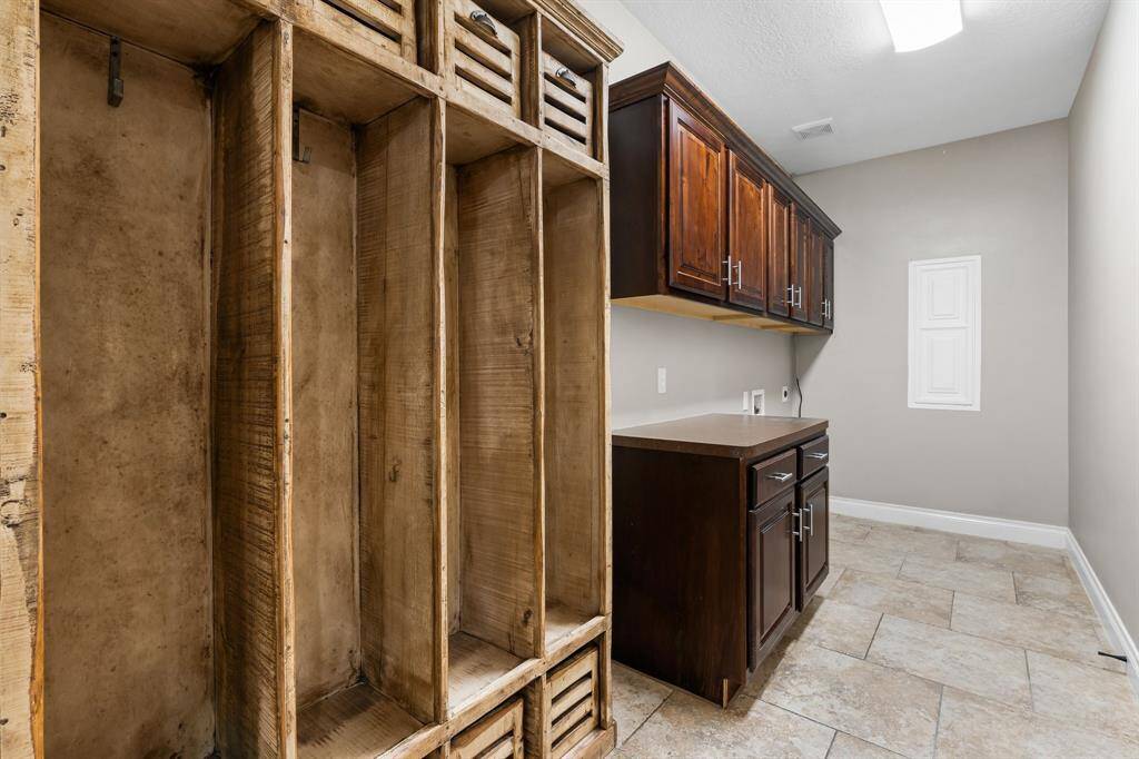Utility room with lockers for staying organized.  There's also a cabinet that's perfect for folding clothes.