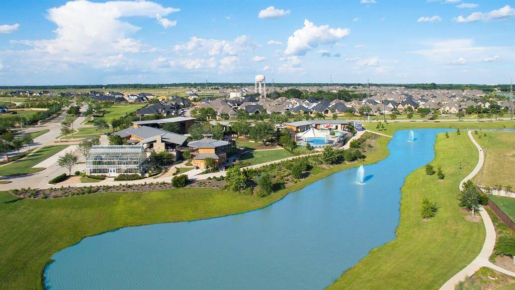 Aerial view of the Cane Island resort-style amenities. Trails surround the entire community, which runners and cyclists enjoy. You can also see Cane Quarter which includes The Conservatory, The Oaks Grille, adult and family pools, yoga studio, gym, loft, and the Ambassador's Suite!