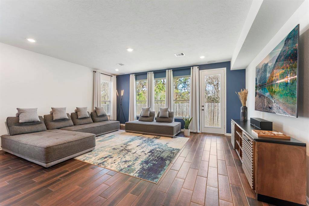 The wood-look tile flooring adds warmth and elegance, perfectly complementing the airy feel of the space. Whether entertaining guests or enjoying a cozy night in, this layout offers the perfect balance of functionality and comfort.