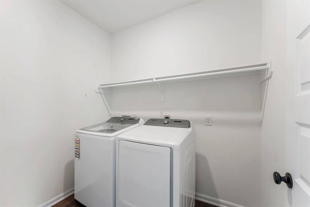 Generously sized laundry room offers hanging space and storage.  Clothes washer and dryer included!