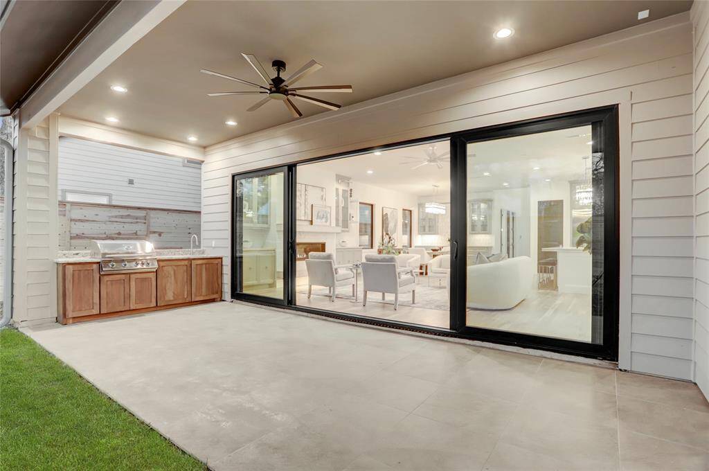 Covered patio and outdoor kitchen:  32 inch stainless steel slide-in grill, 24 inch Undermount sink and mahogany storage cabinetry capped with 3 cm granite and floored with thick porcelain tiles matching the front porch.  Ceiling fan and recessed lighting in the flexible space that works as either outdoor seating or dining.