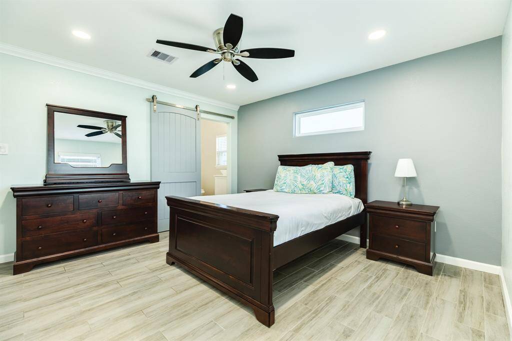 One of the 4 bedrooms with bed, nightstand and dresser.