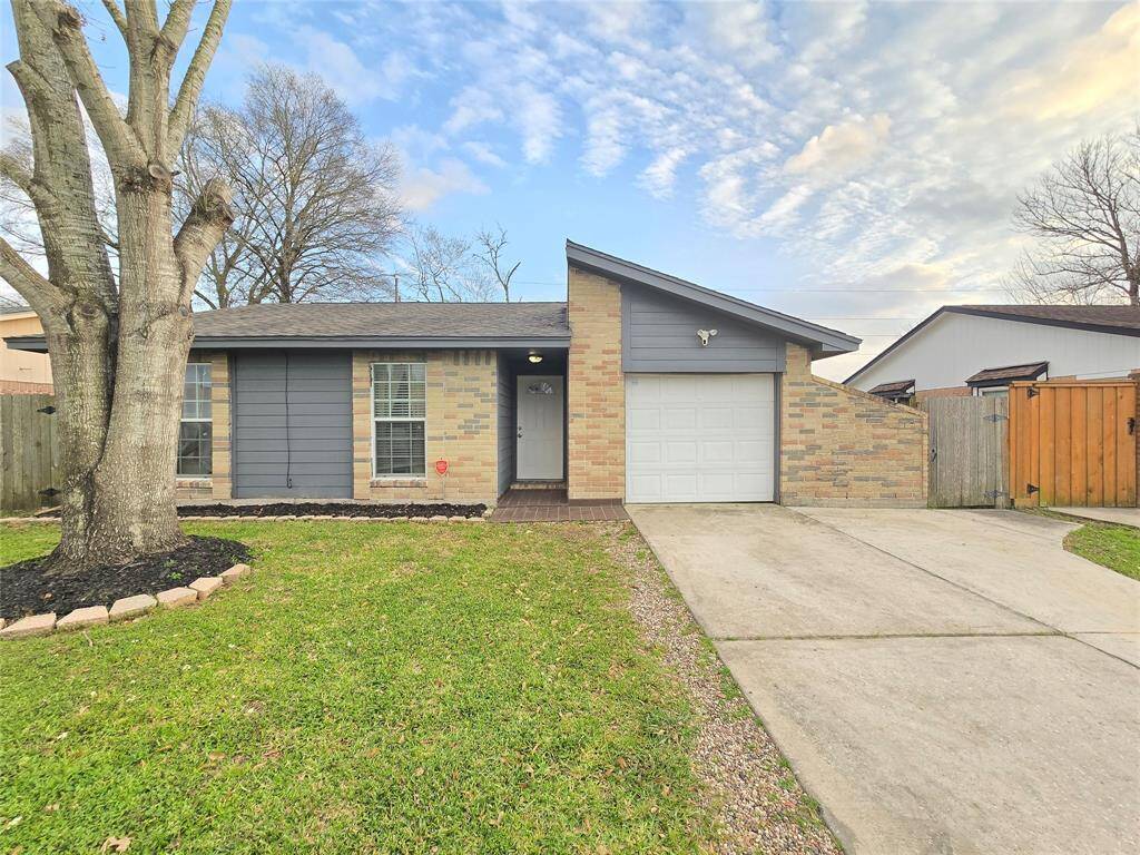 Welcome Home! Features include a mix of brick and siding. It has a single-car garage, spacious driveway, and a well-maintained front yard with mature trees.