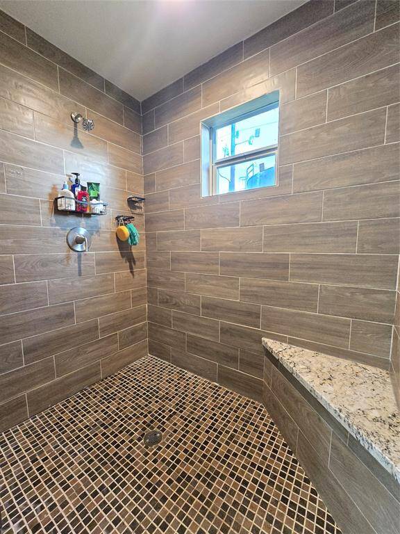 Spacious primary walk-in shower with modern tile work.