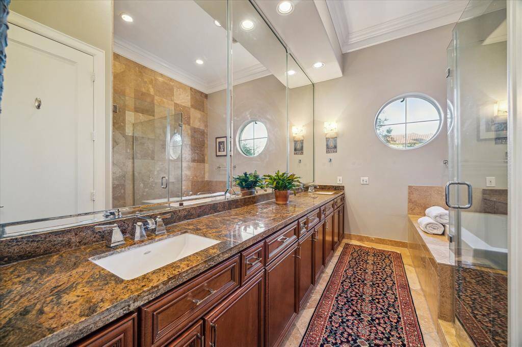 Primary Bath-The primary bathroom offers dual vanity sinks, tile floors and plenty of under cabinet storage