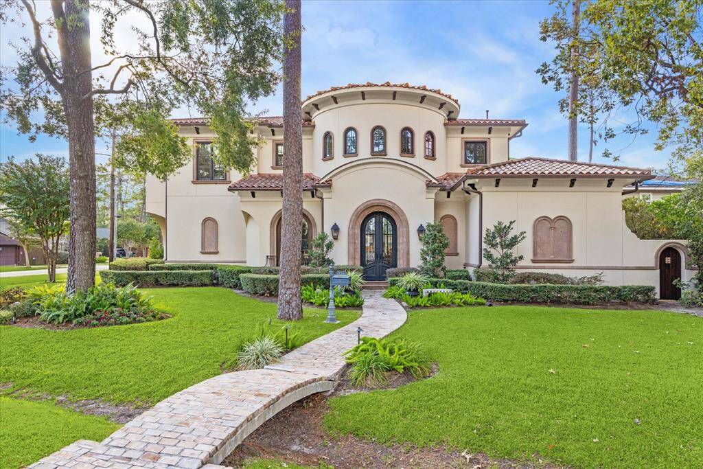 Welcome to 1303 Pine Chase, a custom built home designed by Robert Dame situated on a corner lot. Characterized by arched windows and terracotta roof tiles, a prominent round turret with arched windows, giving the home a distinctive European villa aesthetic.