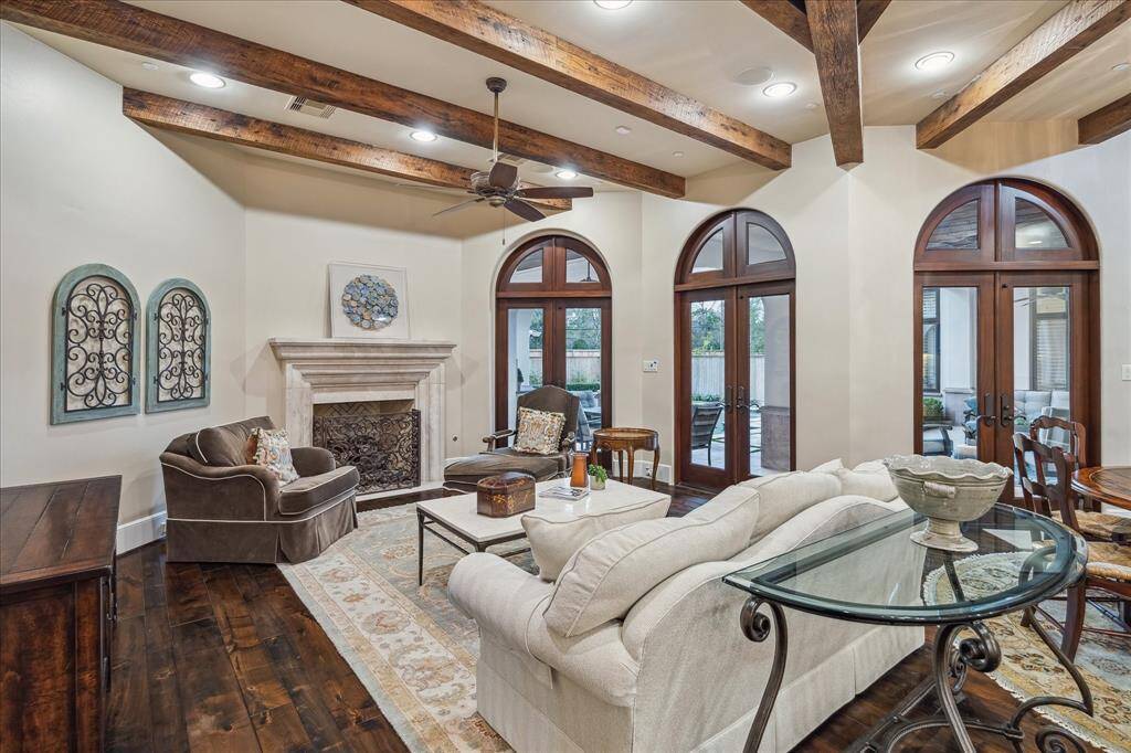 Another view of  family room showcasing exposed beams, wood floors and a beautiful fireplace.