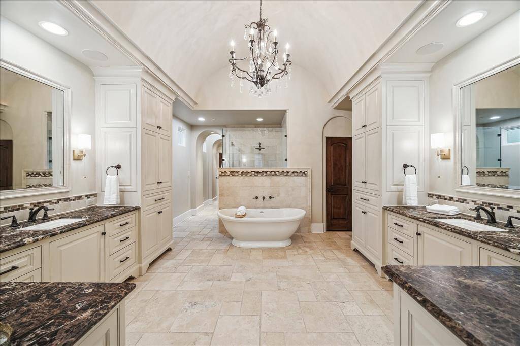 The en-suite bath is a luxurious retreat, designed with symmetry and functionality showcasing a stunning free-standing bathtub, oversized walk-in shower, and two oversized walk-in closets.