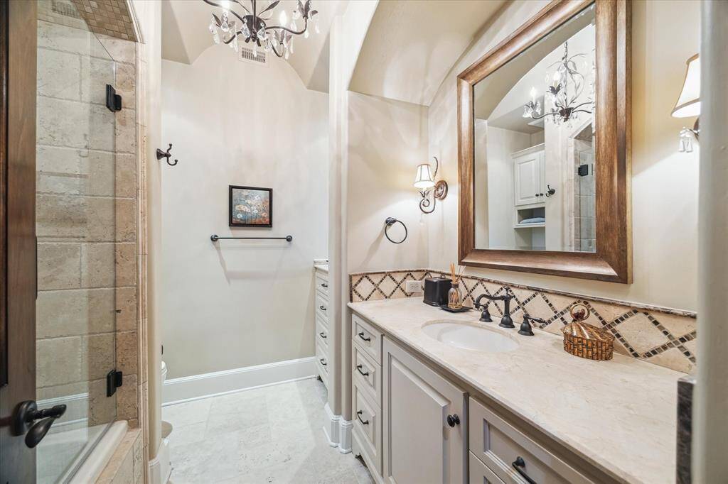 Third bedroom en-suit bath with shower/tub combo, chandelier and sconse lighting.