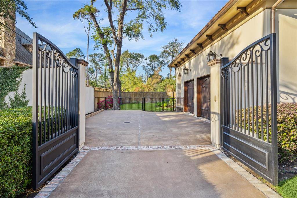 Double wrought iron gates leading to the motor court and three car garage.