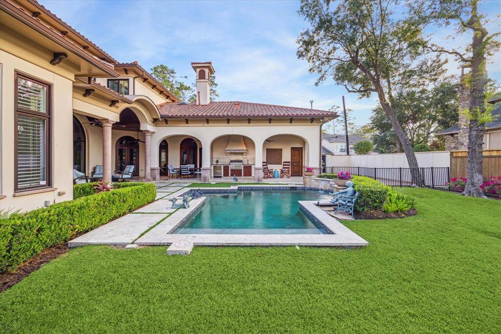 Another view of this tranquil backyard, highlighting the beautiful pool and lush greenery.