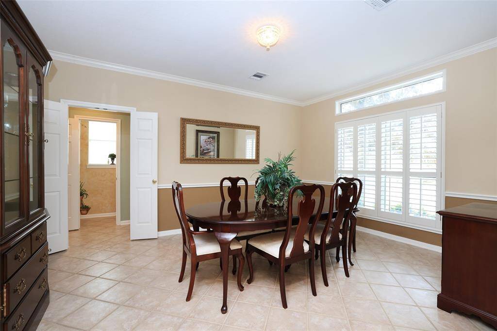 Grand dining room offers shutters, crown molding and chair molding delineates the two tone paint