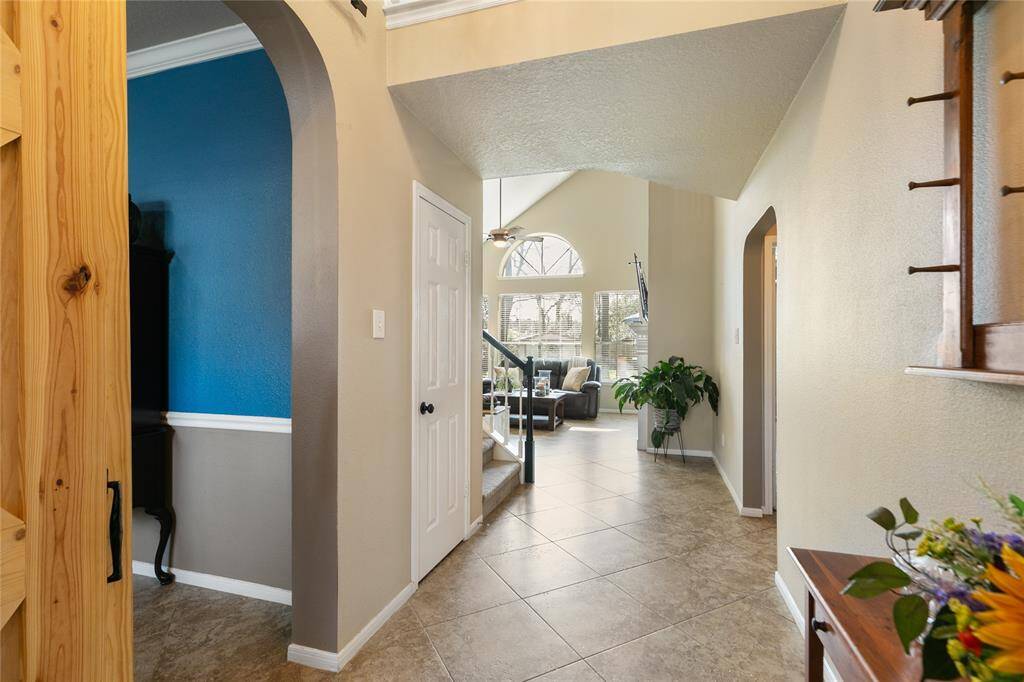 Tiled entry with high ceiling room to the left is the original formal dining room now being used by this owner as a sitting room.