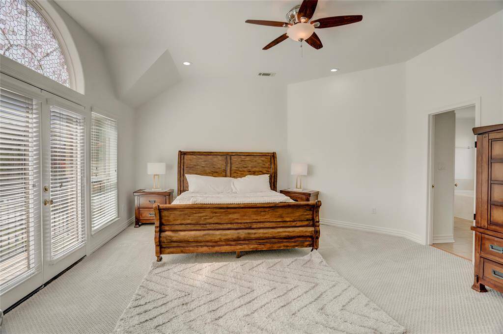 A spacious primary suite with plush high-quality carpeting, vaulted ceilings, and ample natural light.