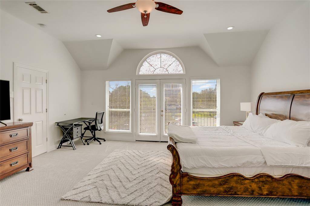 A spacious primary suite with plush high-quality carpeting, vaulted ceilings, and ample natural light.