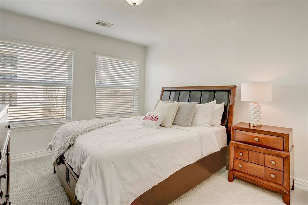 A well-appointed bedroom with plush carpeting, large windows, and a spacious closet.