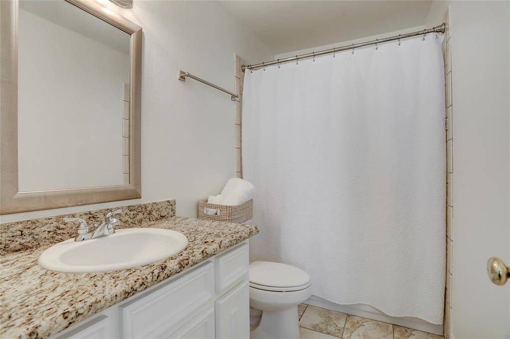 Another angle of the luxurious primary bathroom reveals an elegant granite countertop, adding a touch of sophistication to the space. The rich texture of the granite pairs beautifully with the spa-like finishes, creating a serene and polished retreat.