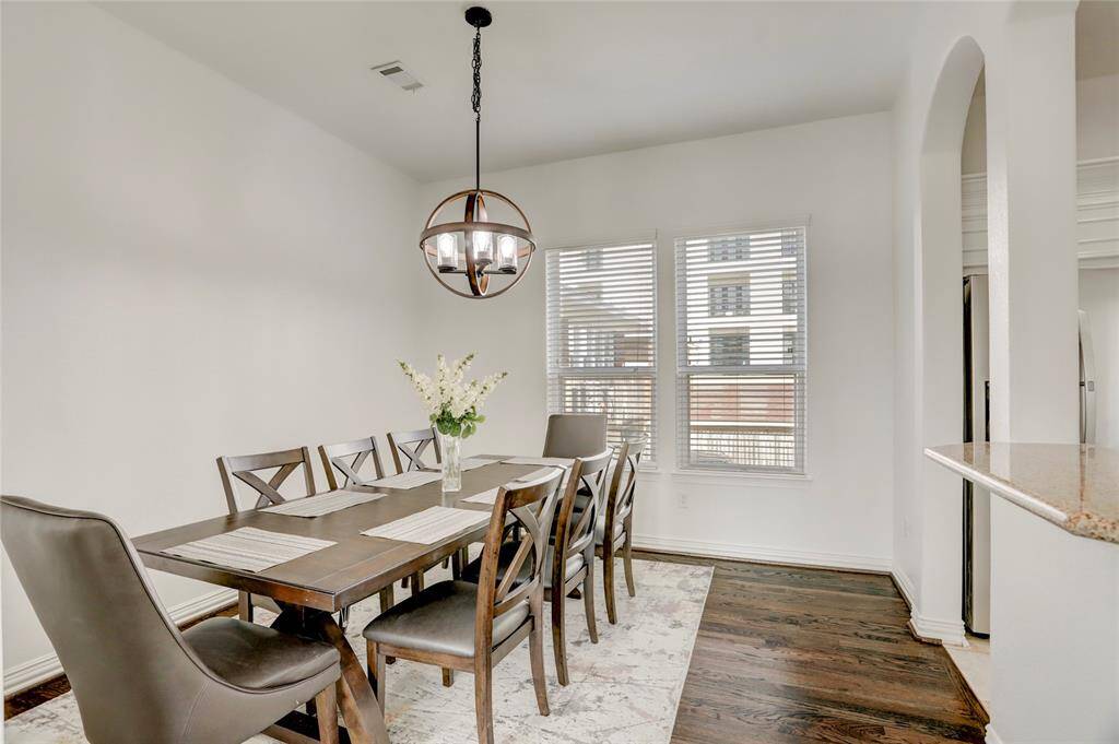 A refined dining space beneath a striking chandelier, perfectly situated for hosting gatherings or intimate meals.