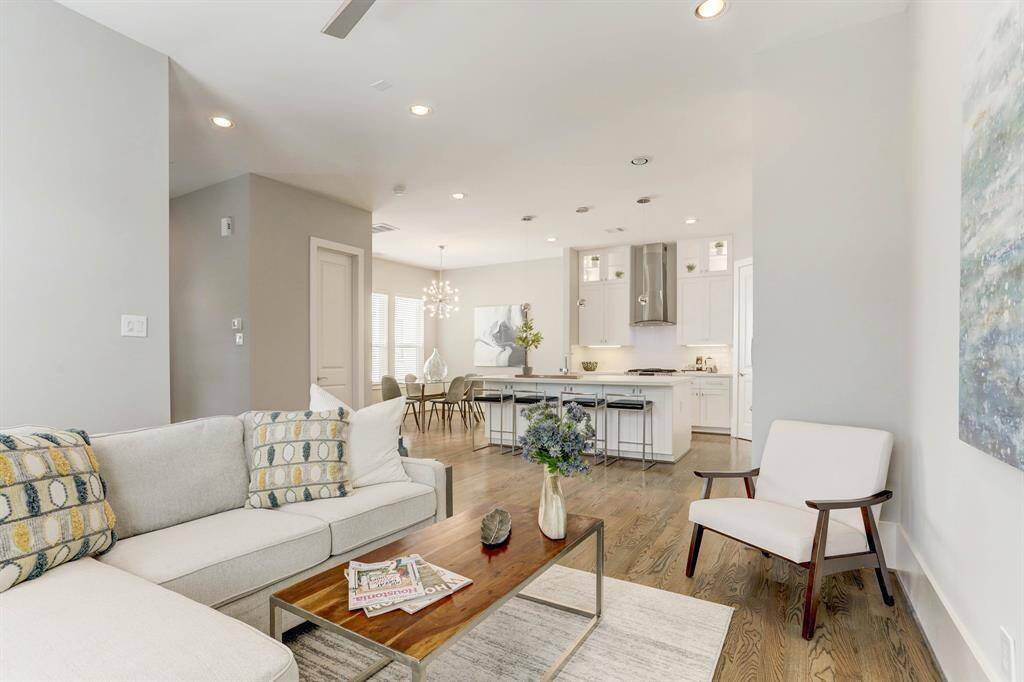 This living area is the epitome of understated elegance with its high ceilings, neutral color palette, and luxurious hardwood floors.