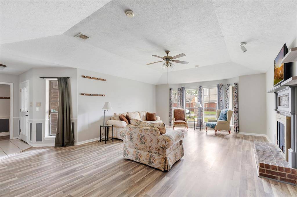Living Room with fireplace, vaulted ceiling, and view of front yard