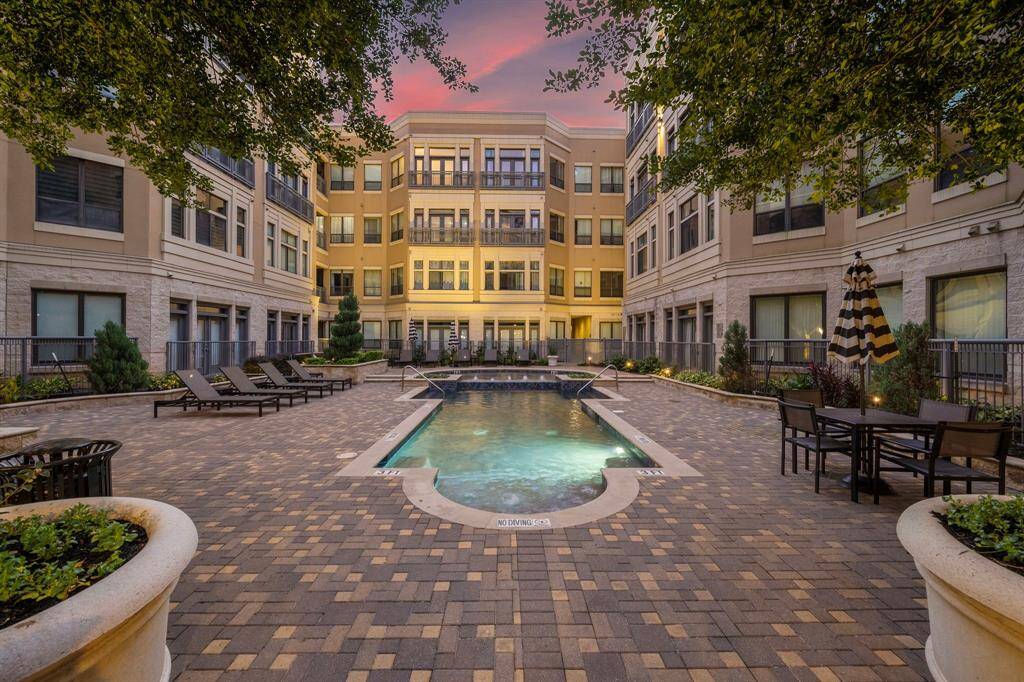 Experience outdoor luxury in an expansive courtyard featuring a spacious pool. Comfortable loungers and shaded seating create a serene retreat for relaxation or social gatherings.