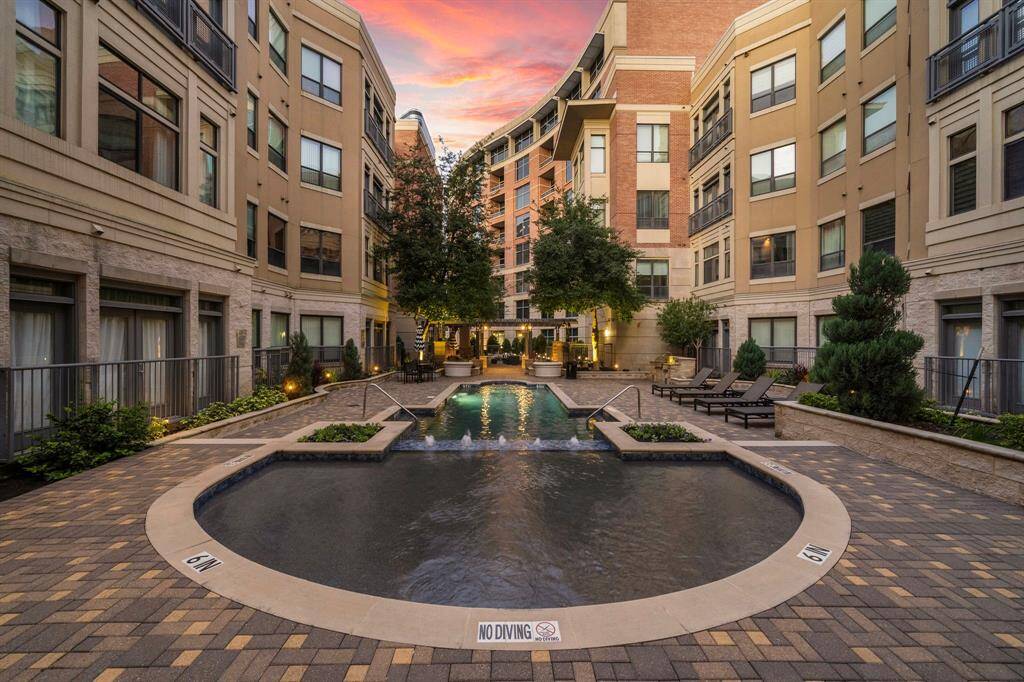 Discover a serene courtyard oasis with a sleek infinity-edge pool and relaxing loungers framed by lush greenery.