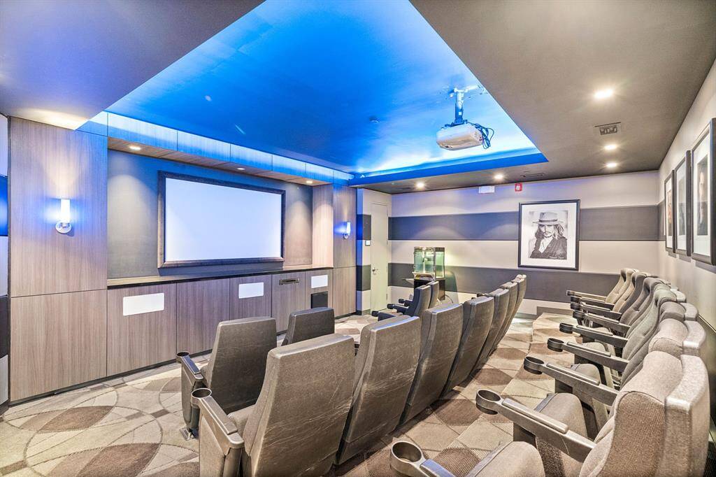 The theater room features tiered, comfortable seating for an immersive viewing experience. Equipped with a high-definition projector and sleek modern design, this space is ideal for movie nights and entertaining guests.