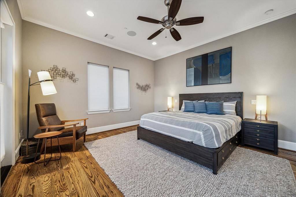 Spacious primary bedroom with abundant natural light from large windows and French doors.