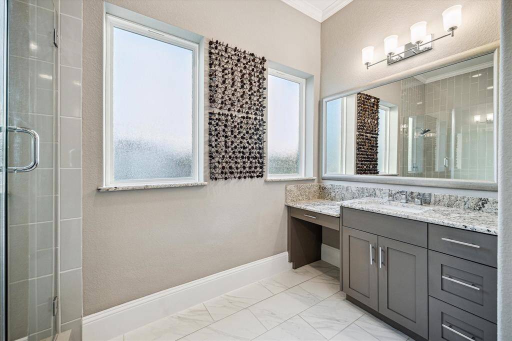 Elegant primary bathroom featuring a spacious double vanity, chic countertops, and abundant natural light for a serene retreat.