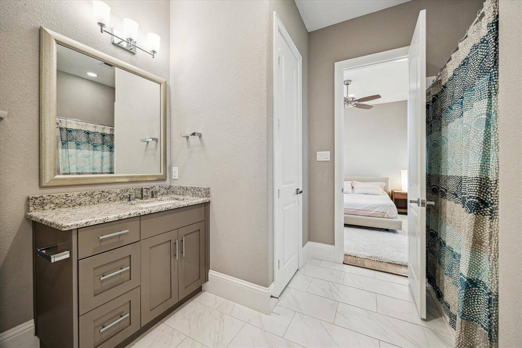 4th-floor bathroom featuring a granite countertop and ample built-in cabinet storage.