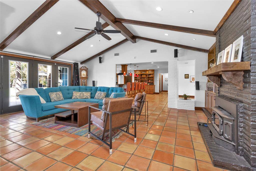 Welcome to 27307 N Creek Drive! The spacious living room features vaulted ceiling with rustic wood beams, but the true highlight is the brick fireplace with a wood-burning insert, perfect for warming even the coldest nights.