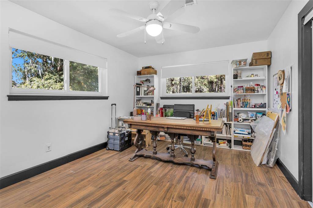 At the end of the hallway leading from the kitchen is the first of three bedrooms located on the first floor. This room is currently utilized as an art studio.