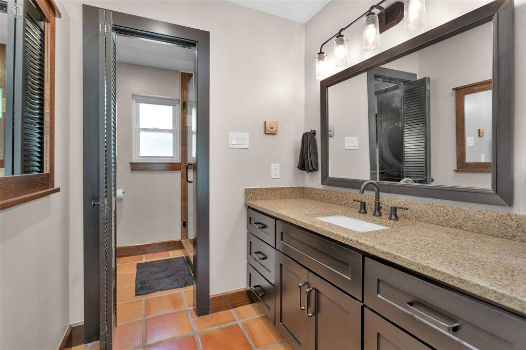 The primary bathroom includes a separate dressing area with ample counter space and cabinets, a walk-in shower, and a linen closet.