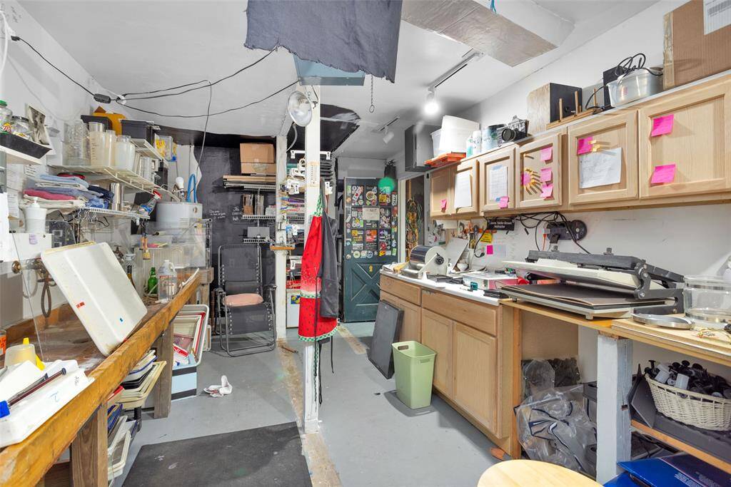 The third bay of the garage is currently utilized as a working darkroom but can be converted back into a parking space or retained as an additional workspace.
