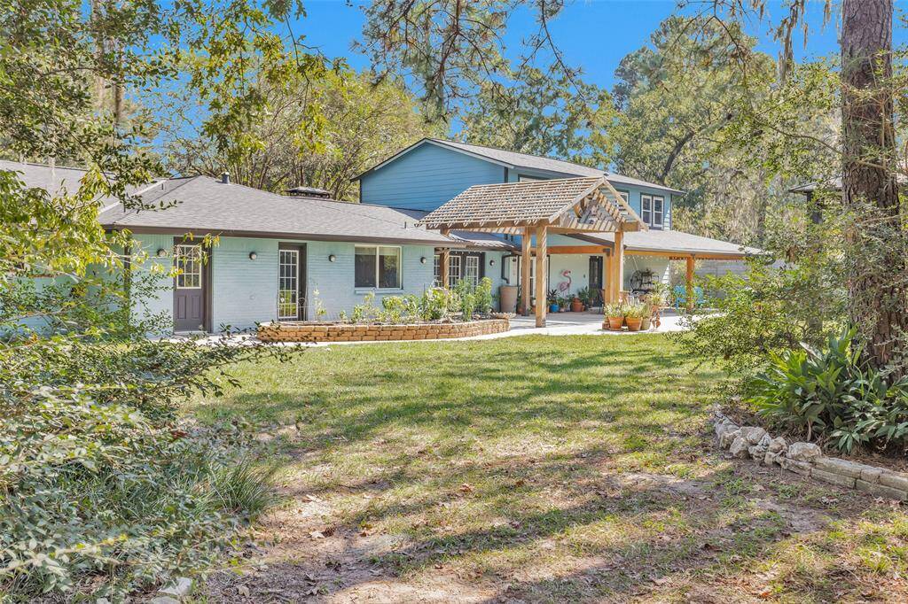 The back of the home is designed for ample entertaining space. The extended back porch features a covered area and a pergola, allowing for plenty of natural light for al fresco dining.