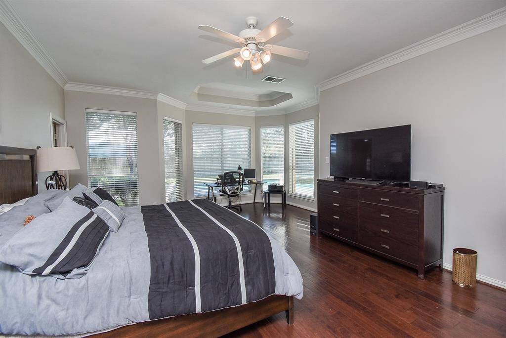 Primary bedroom with bay windows overlooking the pool