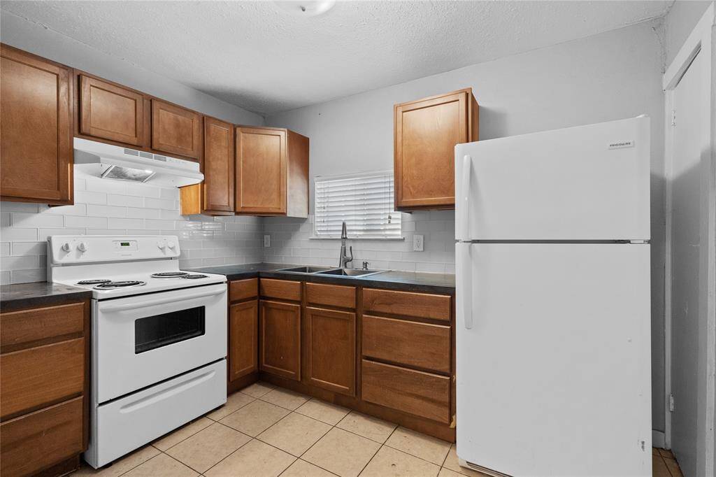 Spacious kitchen with electric stove and ceramic tile flooring