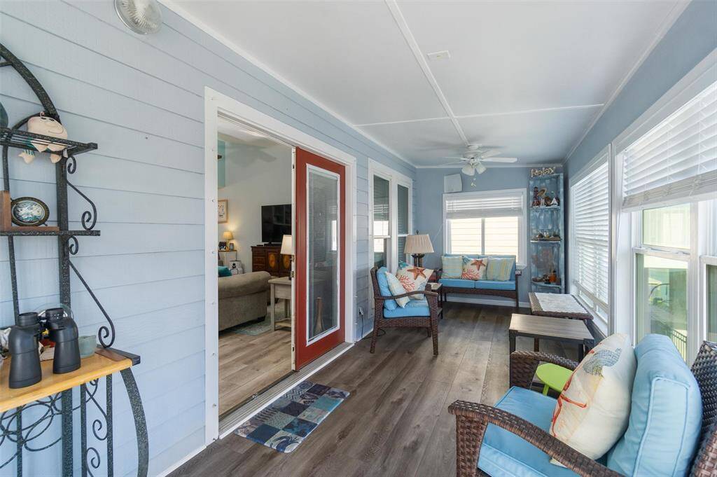 Open living room with vaulted ceilings and French doors out to the sunroom and backyard