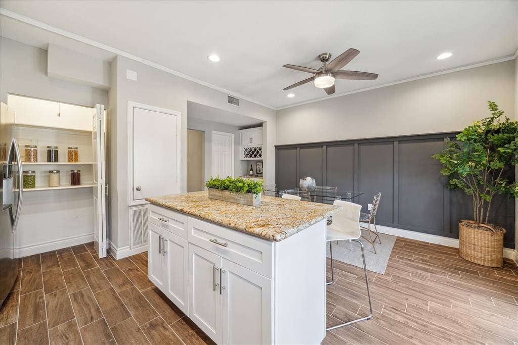 The kitchen island seats 3-4 at bar height and has a sleek wide granite counter to make prep-work and clean-up a breeze.