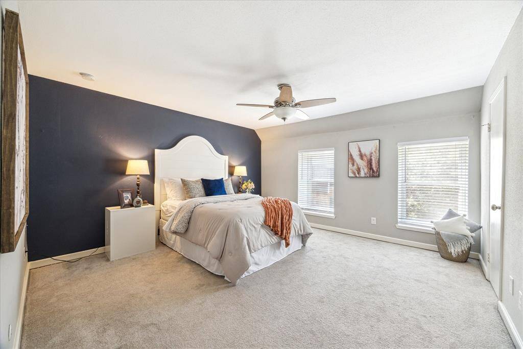 Primary bedroom has en-suite bath, tall ceilings, two large windows, and an oversized closet with plenty of storage room.