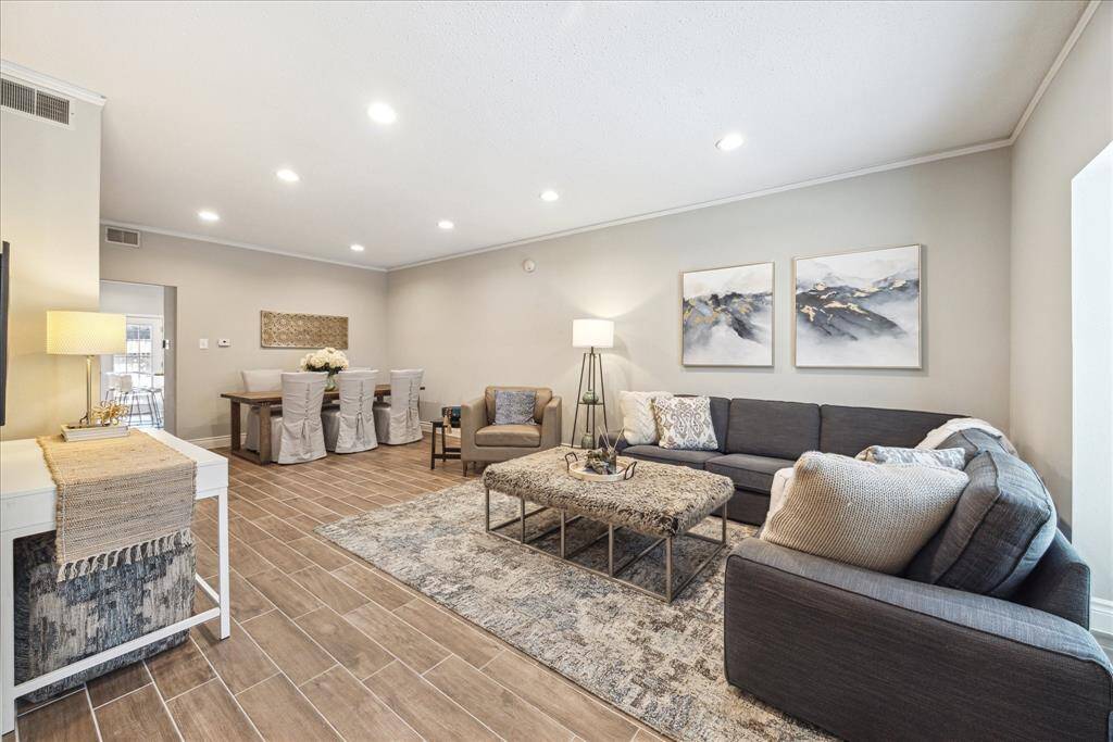 The living space is HUGE! Plenty of room for both living AND formal dining rooms. The window lets in so much light and the wood-style plank tile flooring and neutral color pallet simply enhance the warmth of this space.