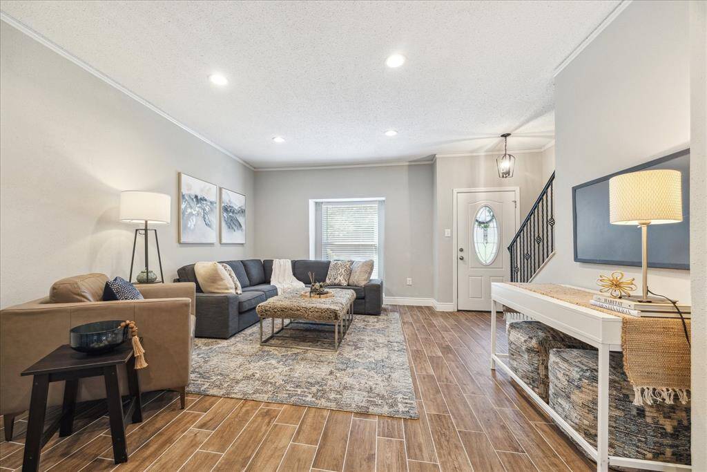 Updated black iron entryway light fixture and wrought-iron staircase spindles are clean, modern touches.