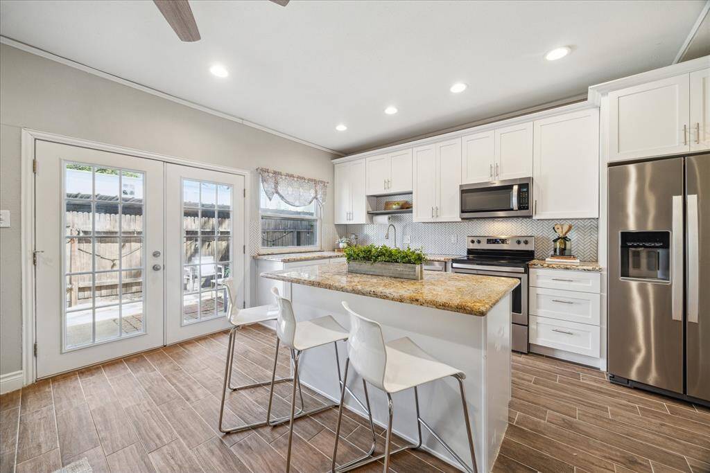 The gorgeous white kitchen with it's herringbone backsplash, stainless steel appliances, 42" cabinets, closet pantry and oversized kitchen island make waking up and winding down just a little bit easier.