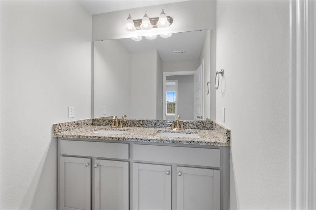 The secondary bathroom has dual sinks