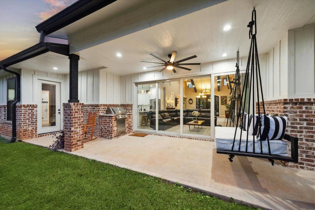 Built-in grill is ready for all the cookouts with friends and family.  “Big Ass” fan cools for summertime entertaining. Just outside the frame of the picture, French doors lead to primary bedroom.