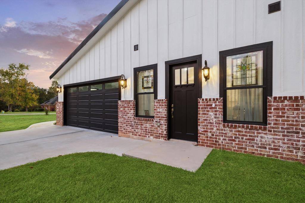 Hardie Plank boards and brick make for an exterior designed for longevity. Door leads to separate guest quarters. Coach lights complete the look.